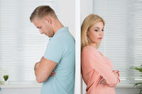 Unhappy Couple Standing Back To Back At Home